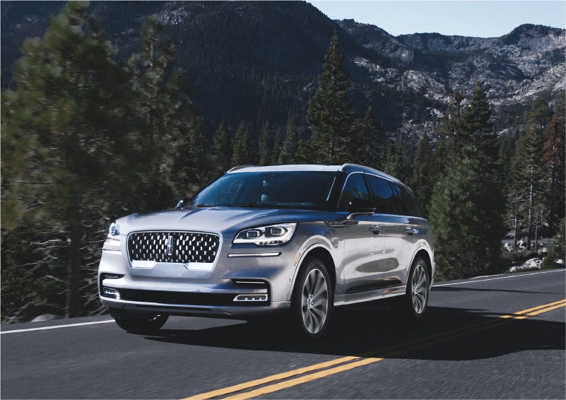 A 2023 Lincoln Aviator® Grand Touring SUV being driven on a winding road to demonstrate the capabilities of all-wheel drive | Irwin Lincoln Laconia in Laconia NH