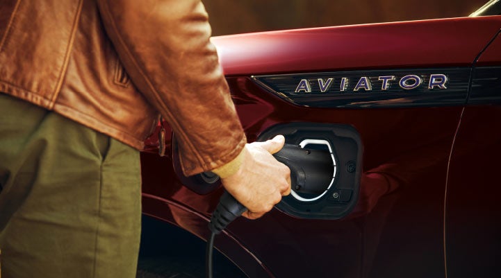 A hand is shown plugging in the charger into the charging port of a 2021 Lincoln Aviator | Irwin Lincoln Laconia in Laconia NH