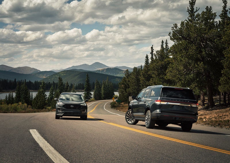 A 2024 Lincoln Navigator® SUV is making a left turn as another vehicle approaches in the other lane.