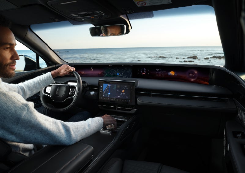 A driver of a parked 2025 Lincoln Nautilus® SUV takes a relaxing moment at a seaside overlook while inside his Nautilus. | Irwin Lincoln Laconia in Laconia NH