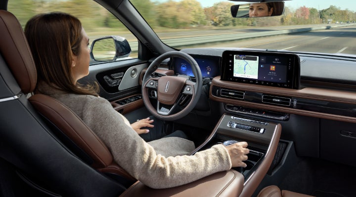 A 2026 Lincoln Aviator® SUV is being driven hands-free on a highway near a forest | Irwin Lincoln Laconia in Laconia NH