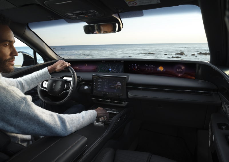 A driver of a parked 2026 Lincoln Nautilus® SUV takes a relaxing moment at a seaside overlook while inside his Nautilus. | Irwin Lincoln Laconia in Laconia NH