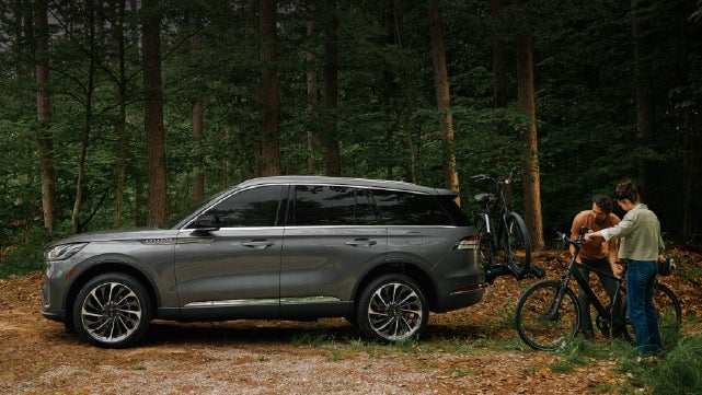 A father and son load e-bikes on a bike rack attached to a 2027 Lincoln Aviator® SUV. | Irwin Lincoln Laconia in Laconia NH